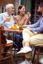 A group of friends of different generations talking while they have a drink in the bar. Leisure, bar, friendship, outdoor