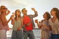 Group of friends with drinks having fun near river at summer party Royalty Free Stock Photo