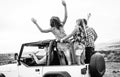 Group of friends driving off road convertible car during roadtrip - Happy travel people having fun in vacation Royalty Free Stock Photo