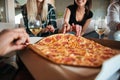 Group of friends eating big pizza and drinking Royalty Free Stock Photo