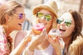 Group of friends eating donuts in the city