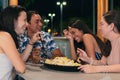 Group of friends eating fast food in a restaurant. Cheerful young people eating and enjoying themselves in a fast food restaurant Royalty Free Stock Photo