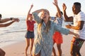 Group of friends enjoy a beach party at sunset Royalty Free Stock Photo