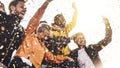 Group of friends enjoying party throwing confetti in the air - Multicultural young students having fun celebrating and laughing Royalty Free Stock Photo