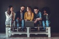 Group of friends enjoying time together and looking at the laptop