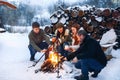 Group of friends gathering around bonfire in backyard, Royalty Free Stock Photo