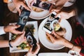 Group of friends going out and taking a photo of Italian food together with mobile phone. Royalty Free Stock Photo