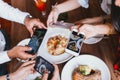 Group of friends going out and taking a photo of Italian food together with mobile phone. Royalty Free Stock Photo