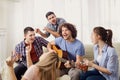 A group of friends with a guitar sing songs at a party indoor Royalty Free Stock Photo