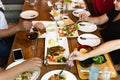 Group of friends hands with fork having fun eating variety food on the table.