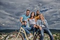 Group friends hang out with bicycle. Company stylish young people spend leisure outdoors sky background. Bicycle as best Royalty Free Stock Photo