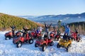 Group of friends having fun in the mountains riding quad bikes in winter on beautiful sunny day Royalty Free Stock Photo