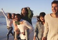 Group Of Friends Having Fun Running Along Winter Beach Together Royalty Free Stock Photo