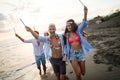 Group of friends having fun running on the beach with sparklers Royalty Free Stock Photo