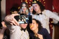 Group of friends having fun and taking a selfie at a Christmas party Royalty Free Stock Photo