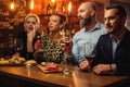 Group of friends having fun talk behind bar counter in a cafe