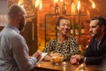 Group of friends having fun talk behind bar counter in a cafe