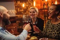 Group of friends having fun talk behind bar counter in a cafe