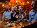 Group of friends having fun talk behind bar counter in a cafe