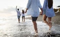 Group of friends having fun and walking on the beach at sunset Royalty Free Stock Photo