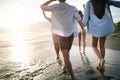 Group of friends having fun and walking on the beach at sunset Royalty Free Stock Photo