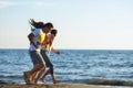 Group of friends having fun walking down the beach at sunset Royalty Free Stock Photo