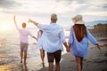 Group of happy friends having fun walking down the beach at sunset Royalty Free Stock Photo
