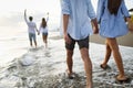 Group of happy friends having fun walking down the beach at sunset Royalty Free Stock Photo