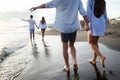 Group of happy friends having fun walking down the beach at sunset Royalty Free Stock Photo