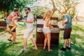 Group of friends having an outdoor garden barbecue. People having a good time, laughing and smiling