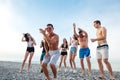 Friends dance on beach under sunset sunlight, having fun, happy, enjoy Royalty Free Stock Photo