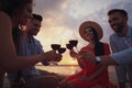 Group of friends having picnic near river at sunset Royalty Free Stock Photo