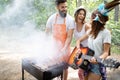 Group of friends having a picnic in a park outdoor. Happy young people enjoying bbq Royalty Free Stock Photo