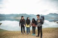 Group of friends with hold hands enjoy lake view