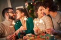 Group of friends holding sparklers celebrating Christmas at home Royalty Free Stock Photo