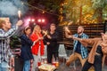 Group of friends holding sparklers out on street at night. Young men and women having night party with sparklers. Royalty Free Stock Photo