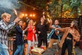 Group of friends holding sparklers out on street at night. Young men and women having night party with sparklers. Royalty Free Stock Photo