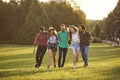 Group of friends hugging during their walk in countryside on summer day. Cheerful people enjoying their weekend outside Royalty Free Stock Photo