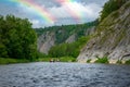 A group of friends in an inflatable raft moving down a river. Mountain river water landscape.