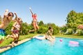 Group of friends jumping in outdoor swimming pool Royalty Free Stock Photo