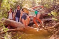 Group Of Friends Jumping Over Tree Trunk On Countryside Walk Royalty Free Stock Photo