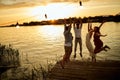 Group of friends jumping on the shore of the lake Royalty Free Stock Photo