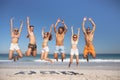 Group of friends jumping together on the beach Royalty Free Stock Photo