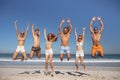 Group of friends jumping together on the beach Royalty Free Stock Photo