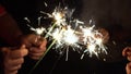 A group of friends lit sparklers together. People get ready for the holiday and light Bengal fires. The company of Royalty Free Stock Photo