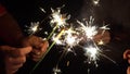 A group of friends lit sparklers together. People get ready for the holiday and light Bengal fires. The company of Royalty Free Stock Photo