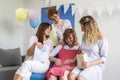 Group of friends in the living room with a baby presents celebrating baby shower