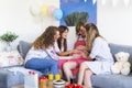 Group of friends celebrating in the living room, holding hands on the belly of the pregnant woman Royalty Free Stock Photo