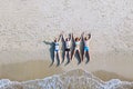 Group of friends lying down on the beach, tropical holidays on the sea, top view Royalty Free Stock Photo