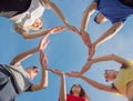 A group of friends makes a circle from the palms of their hands